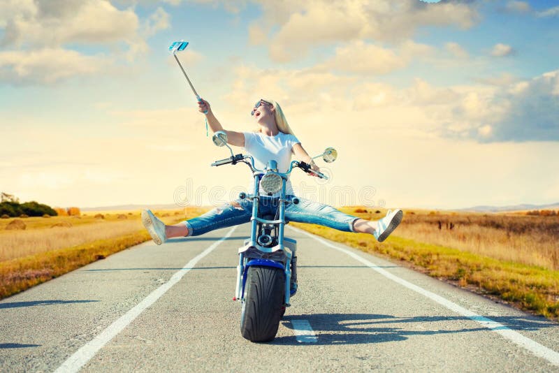 Cycliste de fille montant une motocyclette sur une route goudronnée et photographiée photos libres de droits Cycliste de fille montant une motocyclette sur une route goudronnée et photographiée photos libres de droits