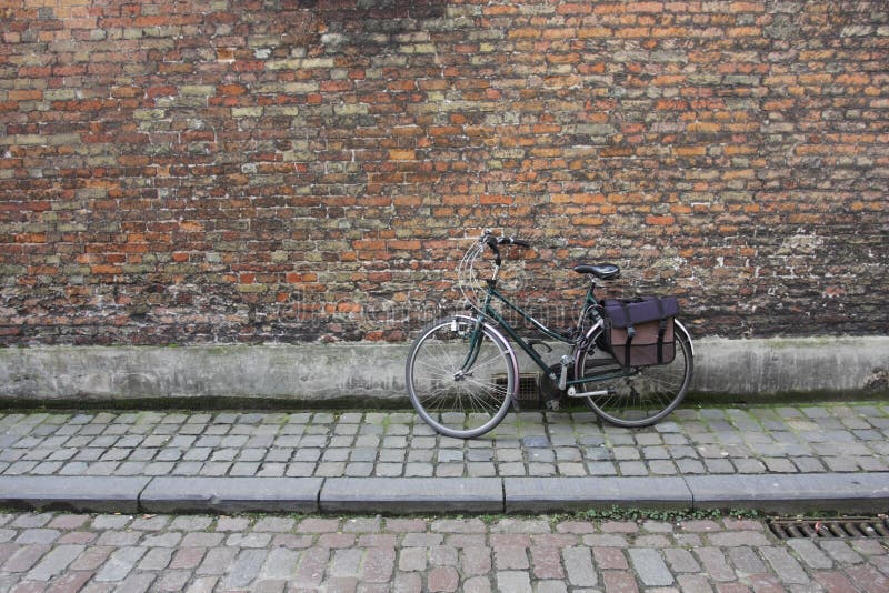 A solitary bicycle leaning against a wall. A solitary bicycle leaning against a wall.