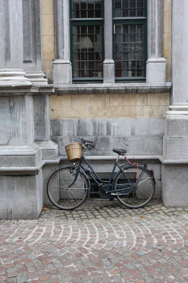 A solitary bicycle leaning against a wall. A solitary bicycle leaning against a wall.