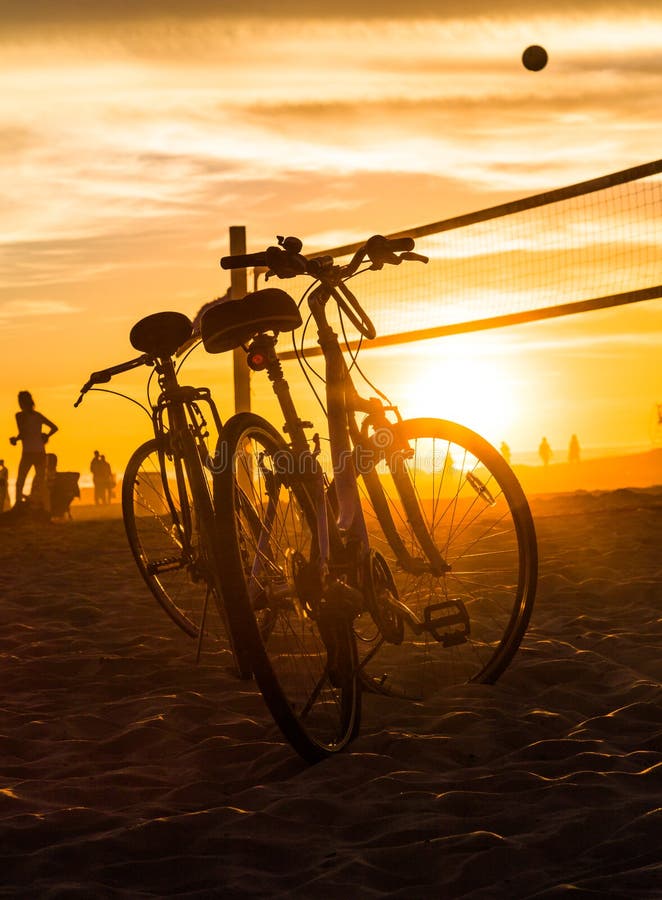 Cykelkonturer och volleyboll förtjänar på stranden royaltyfria bilder Cykelkonturer och volleyboll förtjänar på stranden royaltyfria bilder