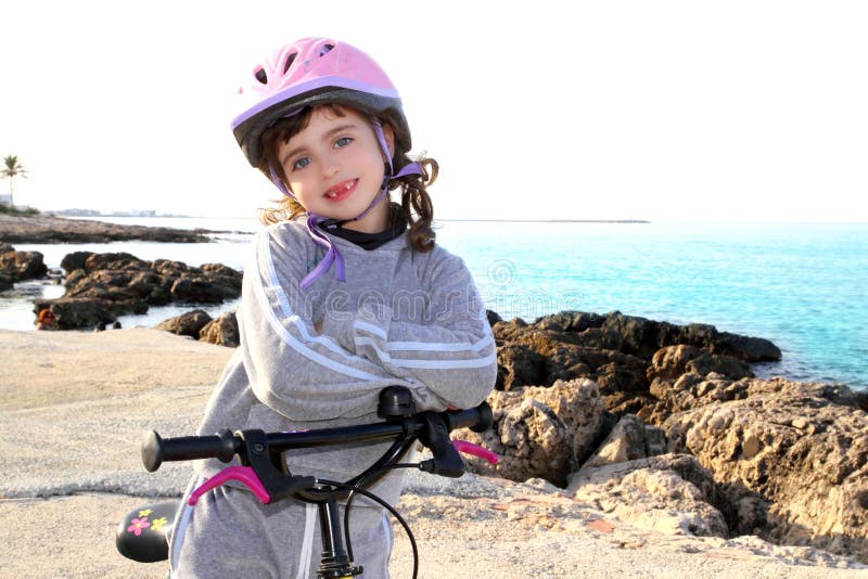 cykla den lyckliga hjälmen för flickan little rosa stenigt hav royaltyfri foto cykla den lyckliga hjälmen för flickan little rosa stenigt hav royaltyfri foto