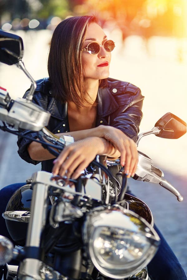 Cyklistflicka i ett läderomslag på en motorcykel arkivfoto Cyklistflicka i ett läderomslag på en motorcykel arkivfoto