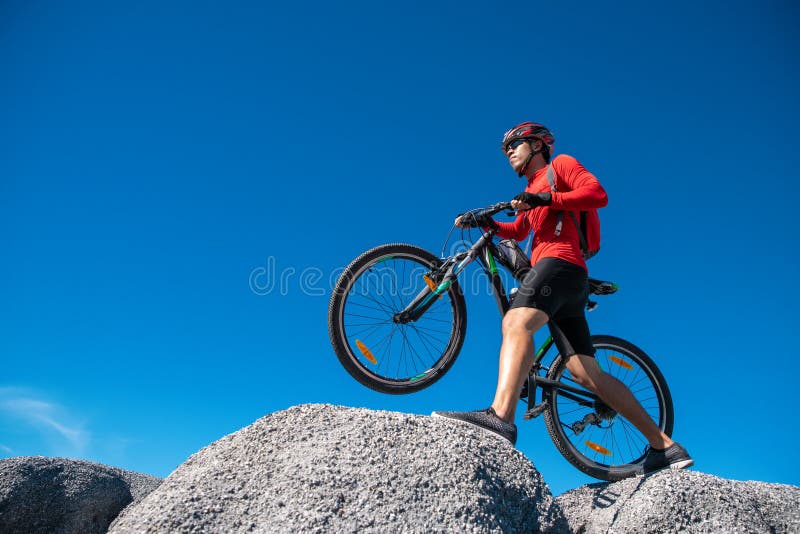 Cyklistridningmountainbike p? den steniga slingan p? solnedg?ngen, extrem man f?r mountainbikesportidrottsman nen som rider det f arkivbilder Cyklistridningmountainbike p? den steniga slingan p? solnedg?ngen, extrem man f?r mountainbikesportidrottsman nen som rider det f arkivbilder