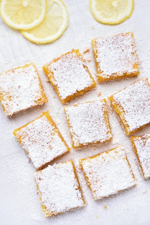 Lemon squares and slices over baking paper, top view. Lemon squares and slices over baking paper, top view