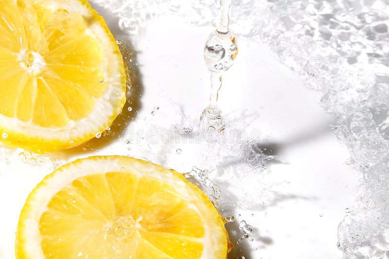 Bright yellow fresh lemon slices and water splash. Tasty and healthy food. Bright yellow fresh lemon slices and water splash. Tasty and healthy food