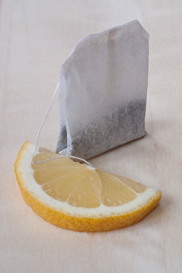 Black tea in teabag with lemon on wooden background. Black tea in teabag with lemon on wooden background.