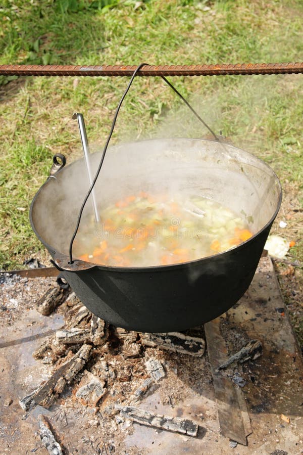 Ear cooks in a kettle on a fire. Ear cooks in a kettle on a fire