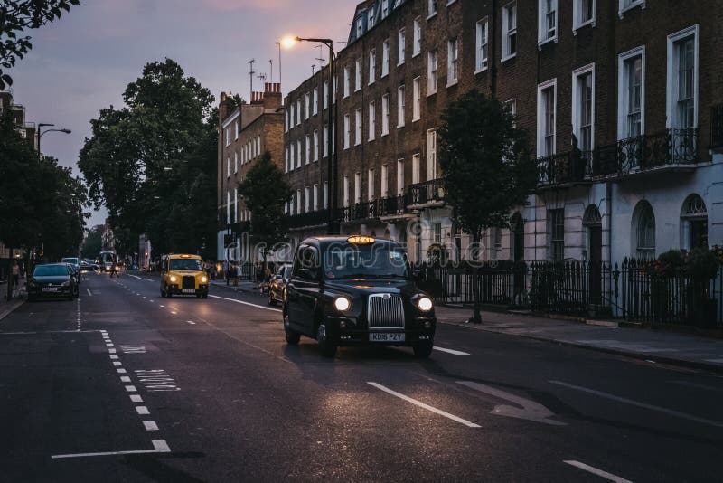 Czarne taksówki z iluminującym taxi podpisują na ulicie w Londyn, UK obrazy royalty free Czarne taksówki z iluminującym taxi podpisują na ulicie w Londyn, UK obrazy royalty free