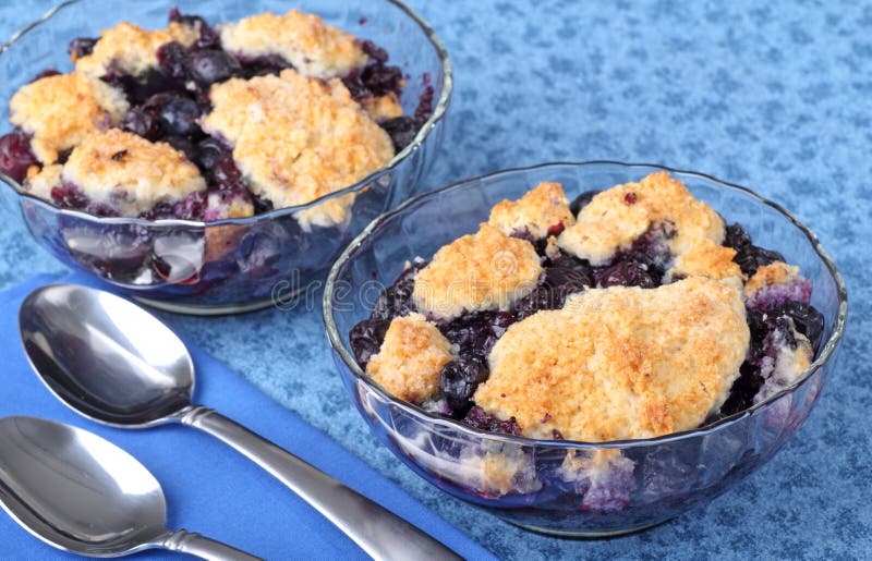 Two glass bowls of blueberry cobbler dessert. Two glass bowls of blueberry cobbler dessert
