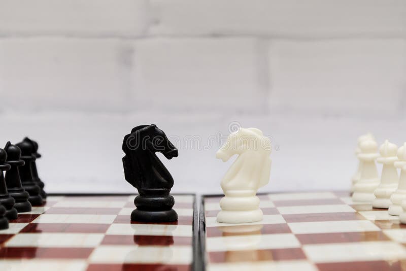 Czarno-biali rycerze szachowi naprzeciwko siebie na szachownicy. koncepcja : strategia szachowa początek walki zdjęcia royalty free