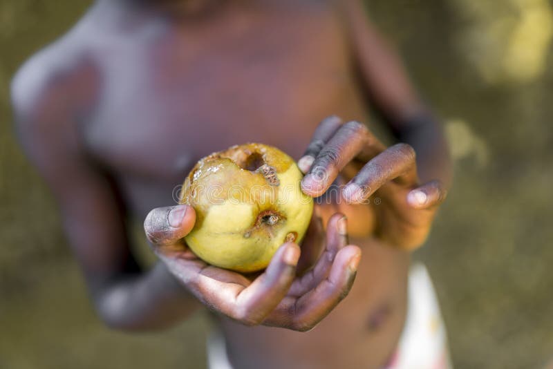 Closeup of black african child holding rotten apple. Closeup of black african child holding rotten apple.