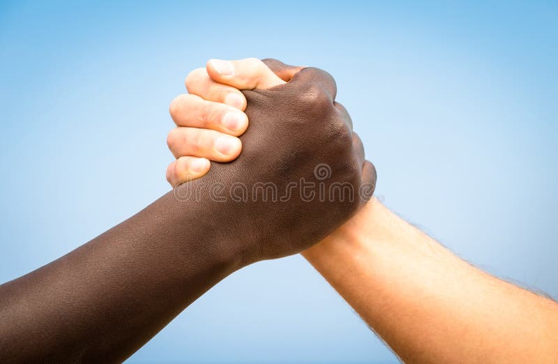 Czarny i biały istot ludzkich ręki w nowożytnym uścisku dłoni przeciw rasizmowi