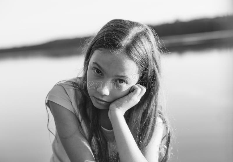 Czarny i biały portret Smutna Piękna nastoletnia dziewczyna patrzeje z poważną twarzą przy nadmorski podczas zmierzchu fotografia stock Czarny i biały portret Smutna Piękna nastoletnia dziewczyna patrzeje z poważną twarzą przy nadmorski podczas zmierzchu fotografia stock