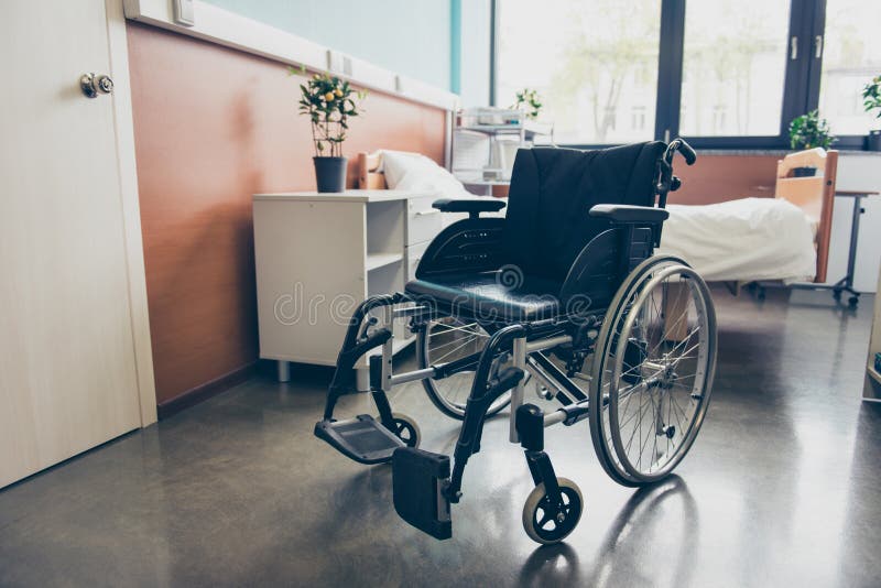 czarny koła krzesło w pustym izbowym oddziale szpital Zamyka w górę fotografii, łóżko jest na tle, biała drzwi medycyna zdjęcie stock czarny koła krzesło w pustym izbowym oddziale szpital Zamyka w górę fotografii, łóżko jest na tle, biała drzwi medycyna zdjęcie stock