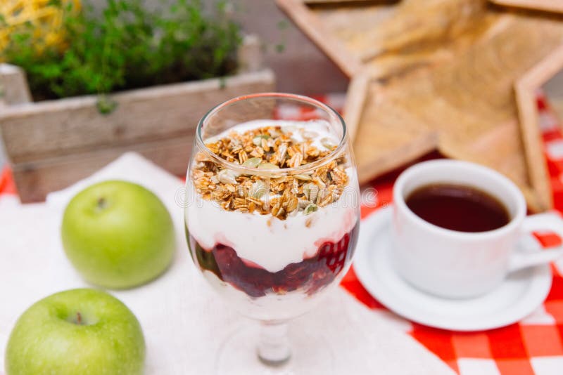 Czereśniowy jogurtu parfait z crispy filiżanką herbata i granola obraz royalty free Czereśniowy jogurtu parfait z crispy filiżanką herbata i granola obraz royalty free