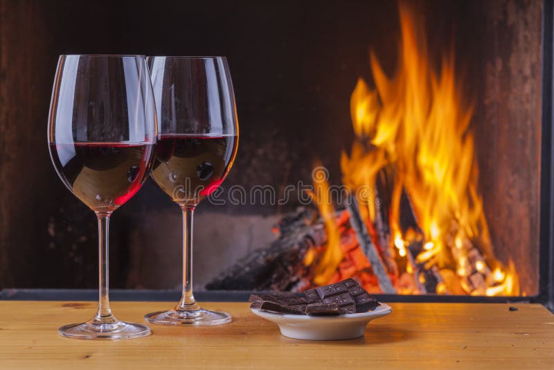 Red wine with dark chocolate at cozy fireplace. Red wine with dark chocolate at cozy fireplace