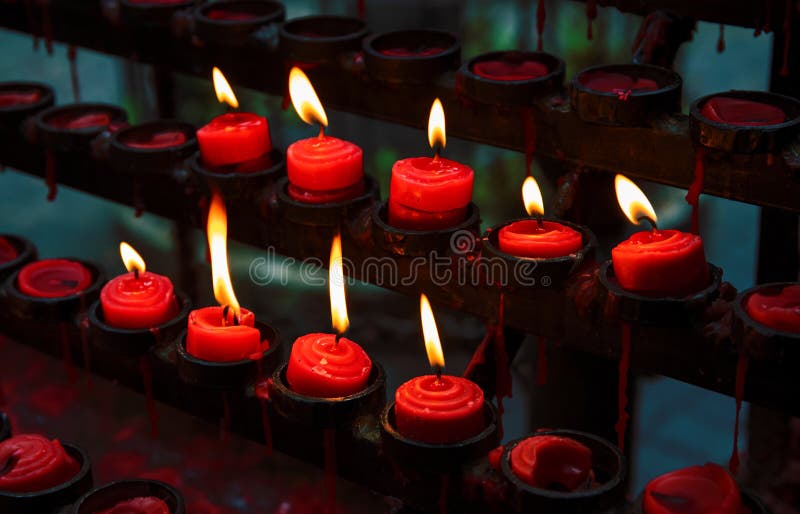 Czerwone świeczki z żółtym płomieniem na kościół katolickiego ołtarzu Płonąca świeczki zbliżenia fotografia In memoriam sztandaru