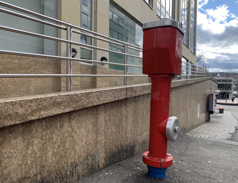 Czerwony hydrant stoi na asfalcie niedaleko budynku w niemieckim mieście pforzheim. zamykanie. zdjęcie gorylowe