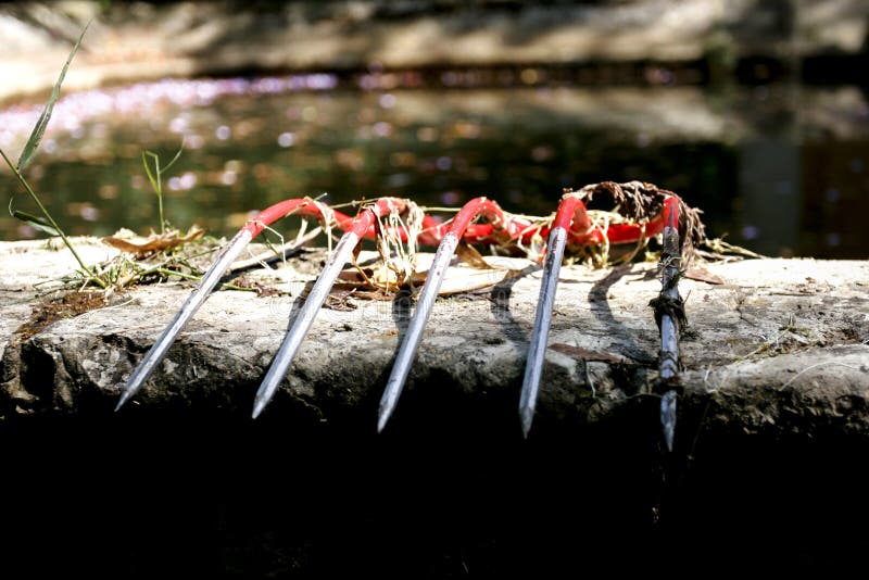 Czerwony pitchfork nad kamienną ścianą obraz stock Czerwony pitchfork nad kamienną ścianą obraz stock