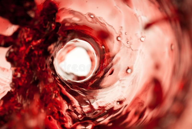 Dark red wine splashing inside a glass bottle. Dark red wine splashing inside a glass bottle