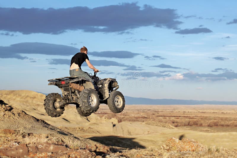 Teen jumping on a quad - four wheeler 4x4 gets some air. Teen jumping on a quad - four wheeler 4x4 gets some air