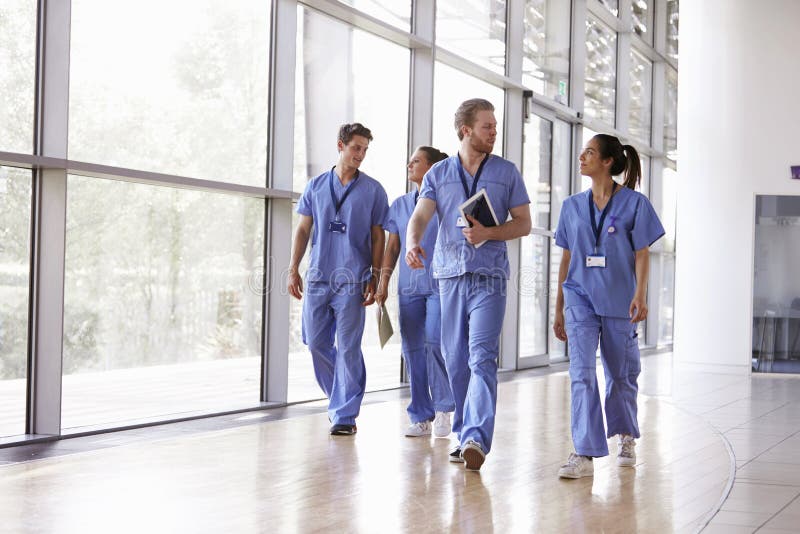 Cztery opieka zdrowotna pracownika chodzi w korytarzu w pętaczkach