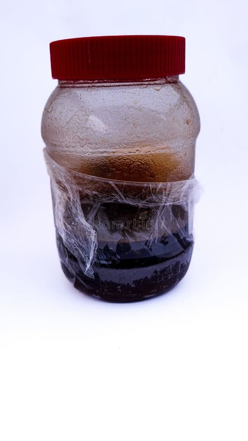 Czysty miód w plastikowym pojemniku z białym tłem. Czysty złoty miód przechowywany jest w przezroczystej plastikowej butelce. Ten produkt naturalny jest bogaty w korzyści zdrowotne i często jest stosowany jako naturalny słodzik w żywności i napojach.