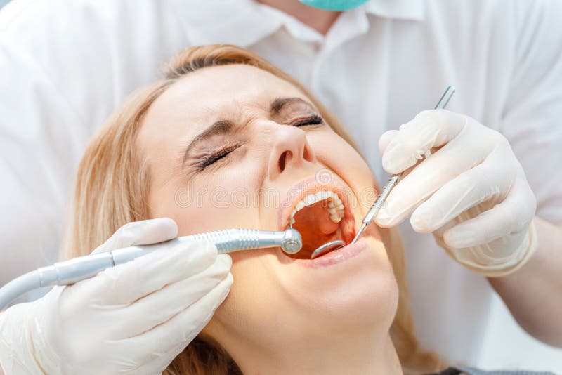 Częściowy widok leczy okaleczającego pacjenta z zamkniętymi oczami dentysta obraz royalty free