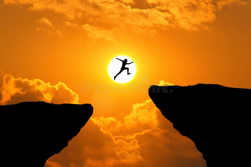 Człowiek przeskakuje przez przepaść między wzgórzem mężczyzna przeskakujący nad klifem