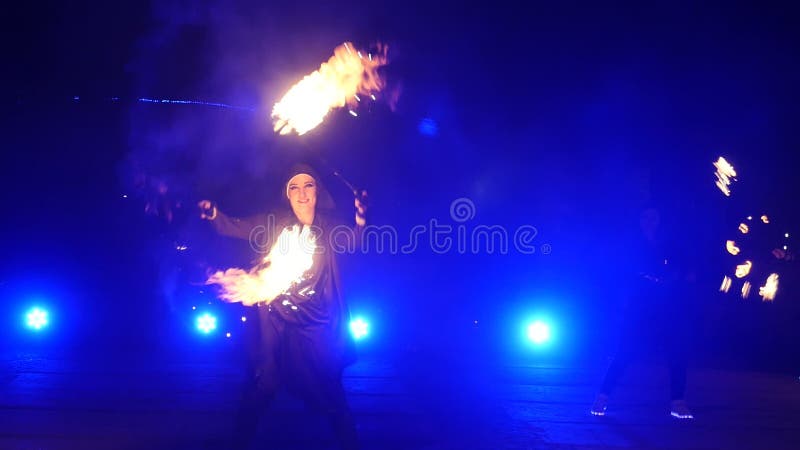 Cámara lenta de la demostración del fuego Los muchachos y las muchachas realizaron danzas con el fuego en la noche en la calle en