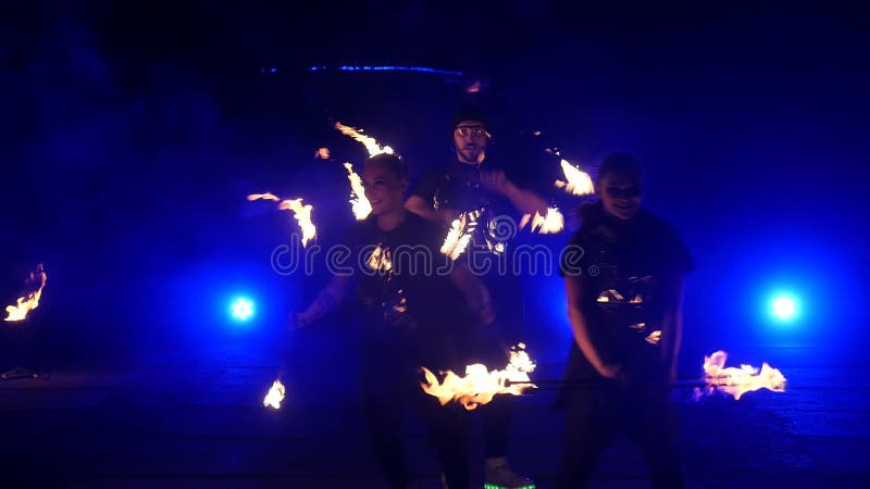 Cámara lenta de la demostración del fuego Los muchachos y las muchachas realizaron danzas con el fuego en la noche en la calle en