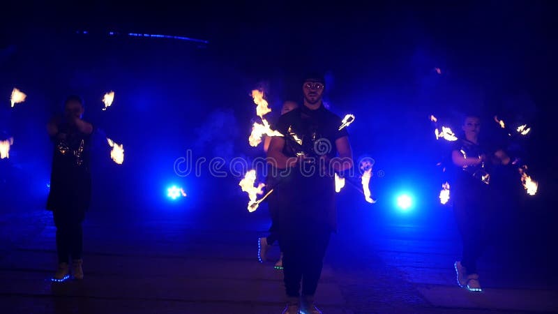 Cámara lenta de la demostración del fuego Los muchachos y las muchachas realizaron danzas con el fuego en la noche en la calle en