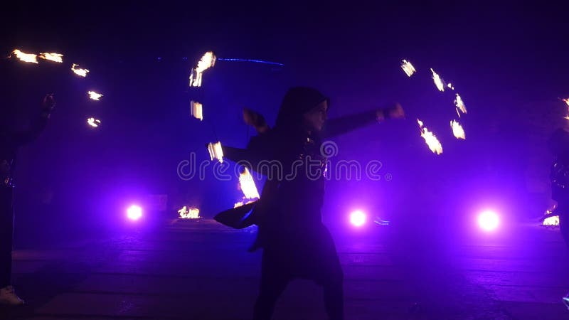 Cámara lenta de la demostración del fuego Los muchachos y las muchachas realizaron danzas con el fuego en la noche en la calle en