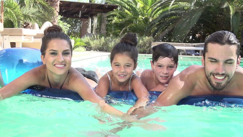 Cámara lenta tirada de la familia en colchón neumático en piscina almacen de video