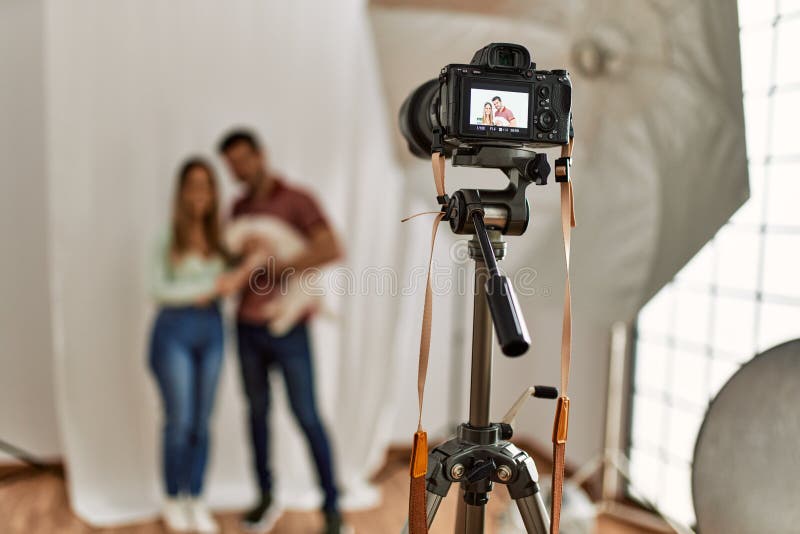 Cámara profesional tomando foto de una hermosa pareja con perro en el estudio de fotografía imagen de archivo libre de regalías