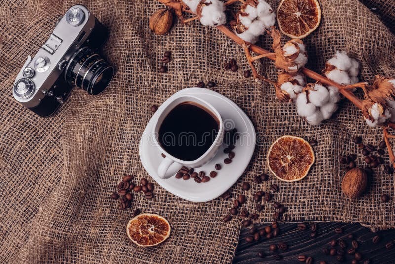 Cámara retra vieja y café del algodón seco en una tabla rústica con BU fotos de archivo libres de regalías Cámara retra vieja y café del algodón seco en una tabla rústica con BU fotos de archivo libres de regalías