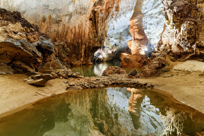 Cámara subterráneo reflejada en agua dentro de la cueva de Phong Nha