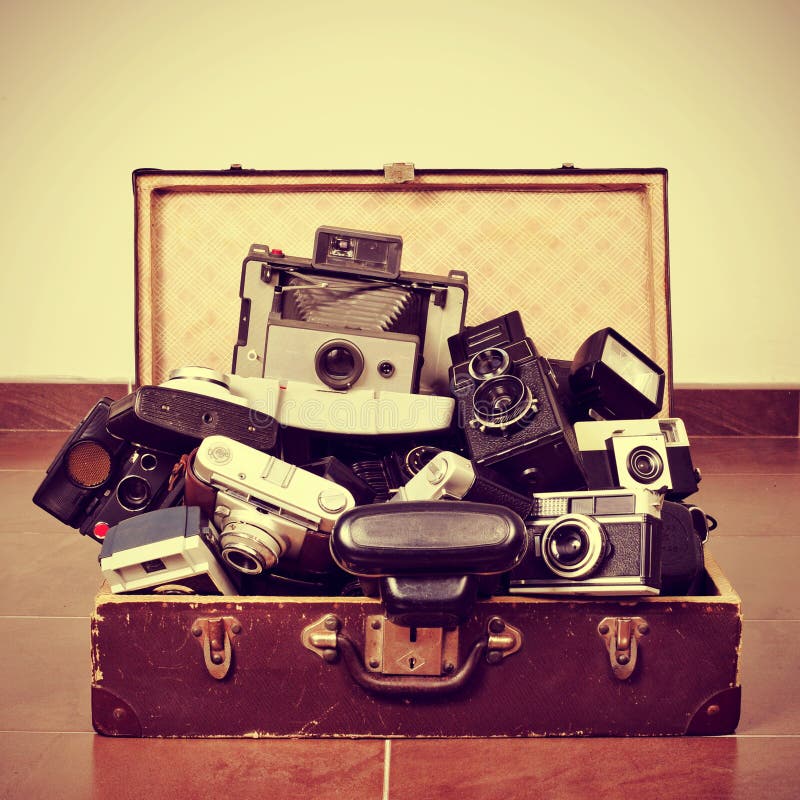 Picture of a pile of old cameras in an old suitcase, with a retro effect. Picture of a pile of old cameras in an old suitcase, with a retro effect