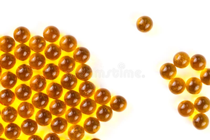 Cápsulas esféricas anaranjadas de la bola de foco selectivo del aceite de pescado aislado en el fondo blanco imágenes de archivo libres de regalías Cápsulas esféricas anaranjadas de la bola de foco selectivo del aceite de pescado aislado en el fondo blanco imágenes de archivo libres de regalías