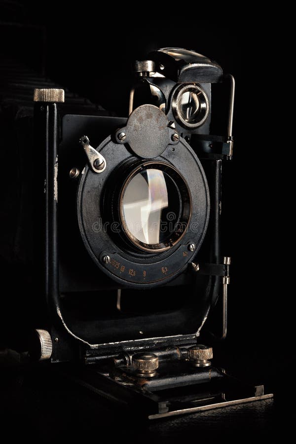 Vintage camera on a black background. Close-up of the lens of an old camera open. Antique items. Vintage camera on a black background. Close-up of the lens of an old camera open. Antique items