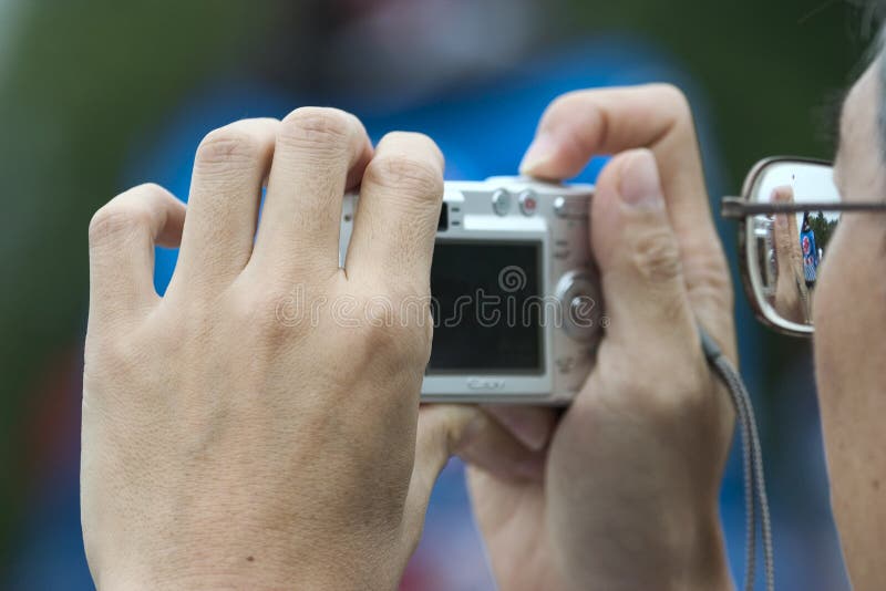 Homem a segurar uma câmara, a tirar fotografias imagem de stock
