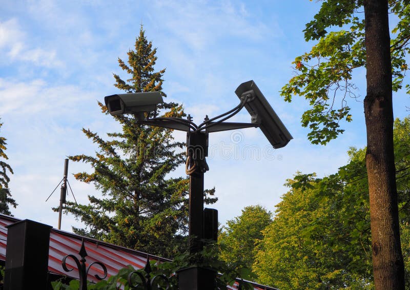 Câmera de vigilância externa instalada no portão do pátio em frente à casa imagem de stock Câmera de vigilância externa instalada no portão do pátio em frente à casa imagem de stock