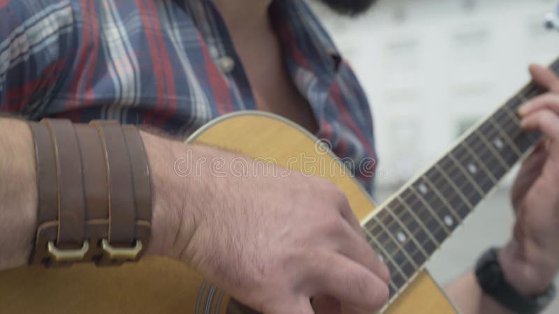 Câmera desce de cara para dedo de guitarrista confiante tocando instrumento musical corda Jovens concentrados