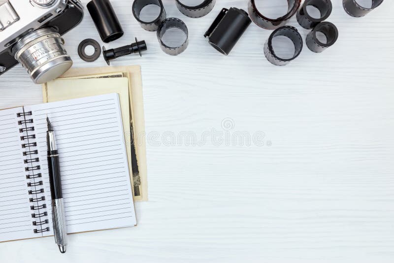 Câmera retro da foto, caderno aberto e rolos de filmes negativos no wh fotos de stock royalty free Câmera retro da foto, caderno aberto e rolos de filmes negativos no wh fotos de stock royalty free