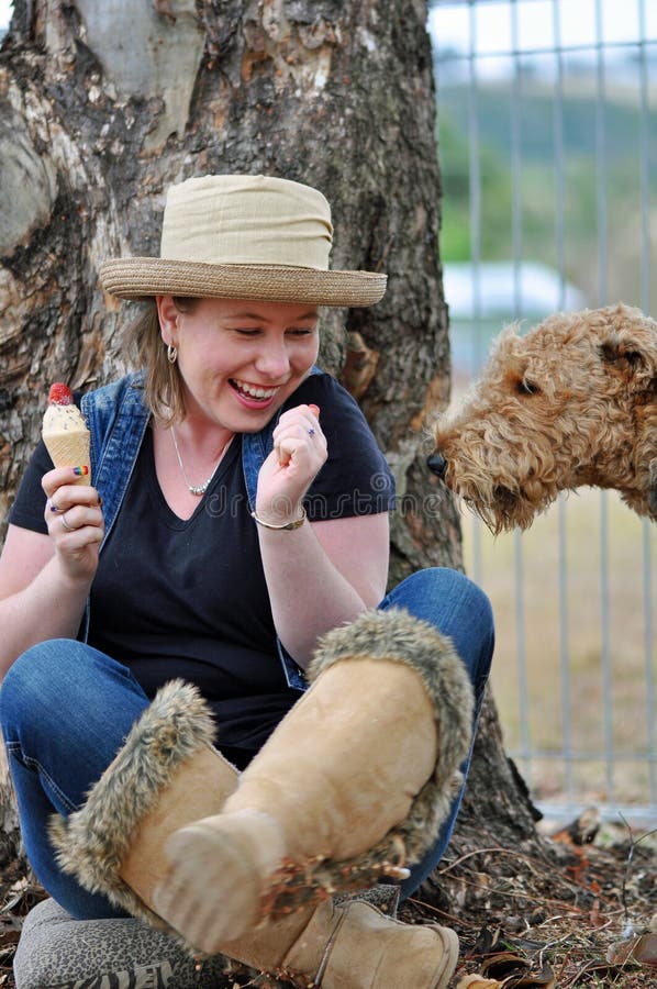 Cão de estimação furtivo inteligente que sneaking até o gelado da pitada esse comer bonito da moça Cão de estimação furtivo inteligente que sneaking até o gelado da pitada esse comer bonito da moça