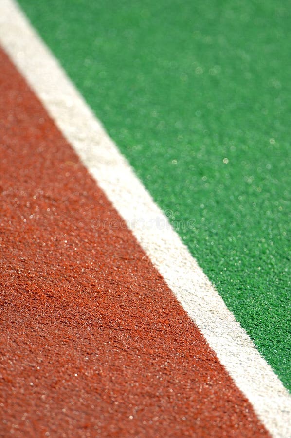 A field hockey pitch made from artificial turf with a ball. A field hockey pitch made from artificial turf with a ball.