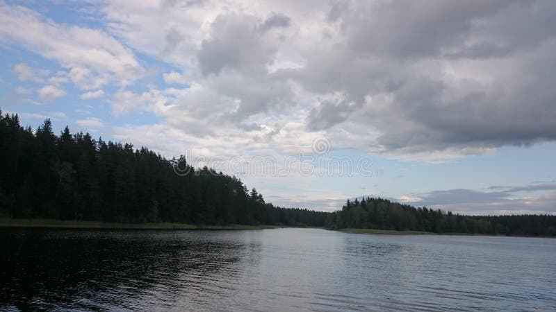 Céu azul e lago azul no verão As nuvens brancas são refletidas na água O lago famoso Seliger Rússia fotografia de stock royalty free Céu azul e lago azul no verão As nuvens brancas são refletidas na água O lago famoso Seliger Rússia fotografia de stock royalty free