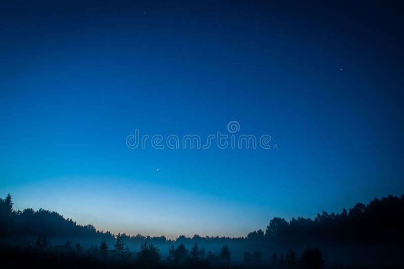 Céu noturno escuro azul com campo acima de muitas estrelas das árvores Cosmos de Milkyway imagem de stock royalty free Céu noturno escuro azul com campo acima de muitas estrelas das árvores Cosmos de Milkyway imagem de stock royalty free