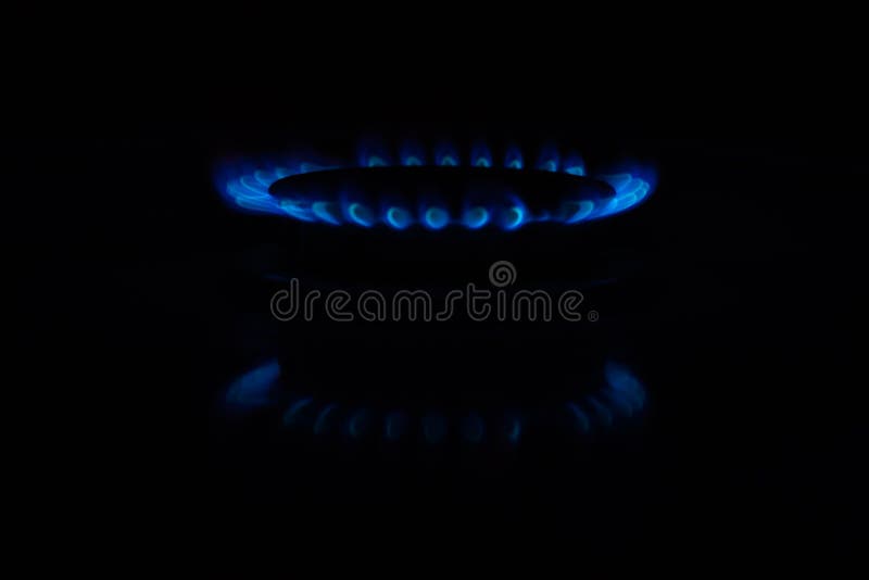 Círculos del fuego en una estufa de gas en la oscuridad Llama azul reflejada en la superficie imágenes de archivo libres de regalías Círculos del fuego en una estufa de gas en la oscuridad Llama azul reflejada en la superficie imágenes de archivo libres de regalías