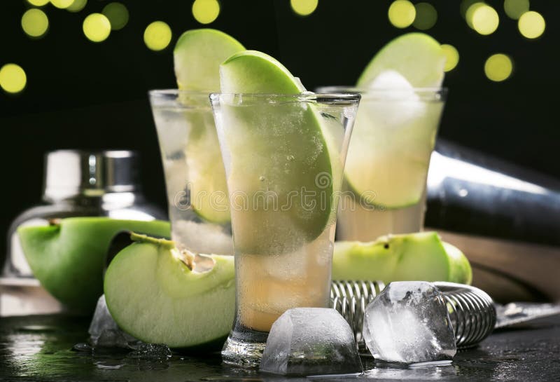 Cóctel alcohólico con el vermú blanco seco, la manzana verde, el jugo, la soda y el hielo, fondo negro del contador de la barra, imagenes de archivo Cóctel alcohólico con el vermú blanco seco, la manzana verde, el jugo, la soda y el hielo, fondo negro del contador de la barra, imagenes de archivo